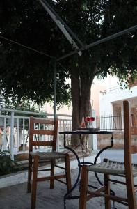 2 Stühle und ein Tisch unter einem Baum in der Unterkunft Sophie's traditional hospitality appartment in Monemvasia