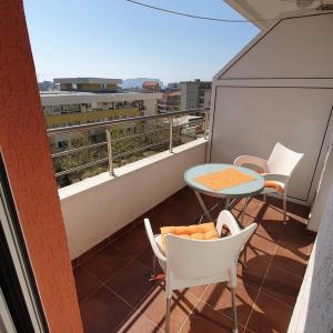 a balcony with a table and chairs on a roof at Apartman Nadja in Budva +1 photo