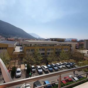 a parking lot with cars parked in front of a building at Apartman Nadja in Budva