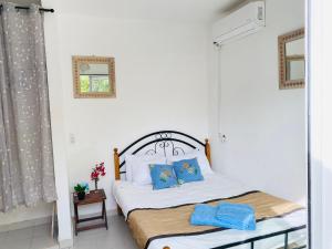 a bedroom with a bed with blue pillows at Keur Madior in Ngaparou