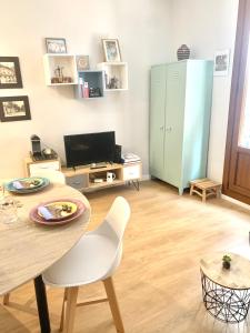 a living room with a table and chairs and a television at Apartamento Catedral - Casco Antiguo Tarragona in Tarragona