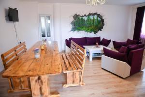 a living room with a wooden table and a couch at Manana Guesthouse in Marmarik