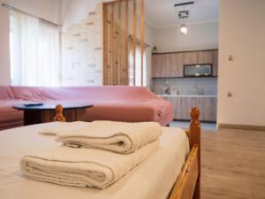 two beds with towels on them in a room at Kellys cozy one bedroom house next to the beach in Oikonomiánika