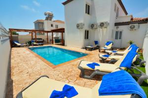 een terras met stoelen en een zwembad bij Nissi Villa Sotia in Ayia Napa