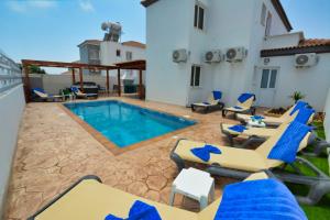 een villa met zwembad en ligstoelen bij Nissi Villa Sotia in Ayia Napa
