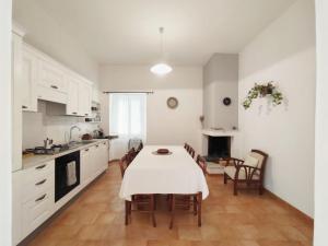 a white kitchen with a table and chairs in it at Il Casale in Teulada