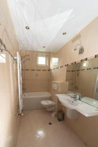 een badkamer met een wastafel, een toilet en een bad bij Hotel Ezeroto in Stara Zagora