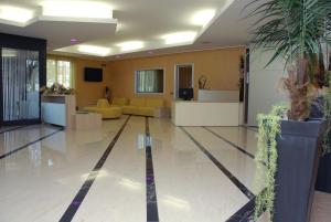 un gran vestíbulo con muebles amarillos y una maceta en Groane Hotel Residence, en Cesano Maderno