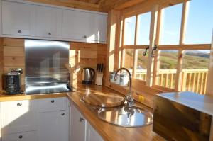 a kitchen with a sink and a window in a cabin at Seillean Trang in Saasaig