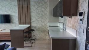 uma cozinha com um lavatório e um balcão com bancos em Ege Birlik em Kusadası