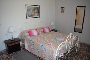 een slaapkamer met een groot bed met roze kussens bij Dimora in collina in Monopoli
