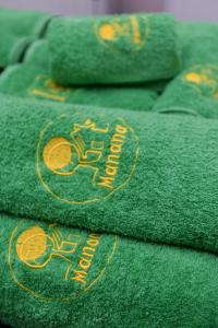 a group of green towels with gold writing on them at Manana Guesthouse in Marmarik