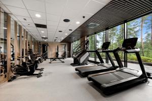 a gym with treadmills and ellipticals in a room with windows at The Well in Kolbotn