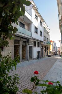 an empty street with a white building and a red flower at Apartamento reformado en Portonovo in Portonovo