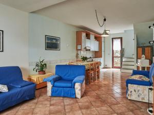 uma sala de estar com cadeiras azuis e uma cozinha em Holiday Home Rustico Belvedere-3 by Interhome em Colico