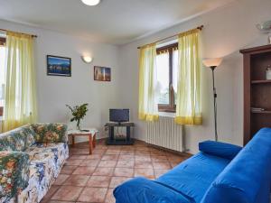 uma sala de estar com um sofá azul e uma televisão em Holiday Home Rustico Belvedere-3 by Interhome em Colico