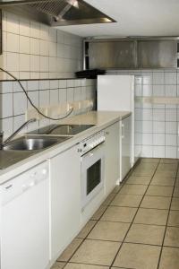 a kitchen with white cabinets and a sink at Villa Burg Biedenegg mit Schlosscafé - FIE211 by Interhome in Alterzoll