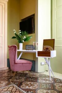 un soggiorno con sedia rosa e scrivania di Castle Elvira a Trepuzzi