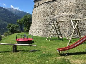 a playground in front of a castle with a swing at Apartment Burg Biedenegg- Potzner - FIE203 by Interhome in Fliess