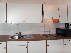 a kitchen with white cabinets and a sink at Apartment Burg Biedenegg- Potzner by Interhome in Fliess