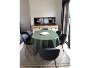 a dining room with a green table and chairs at Rayon de soleil Arcachon in Arcachon +19 photos
