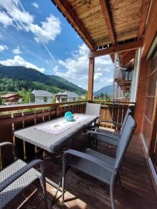 patio ze stołem i krzesłami na pokładzie w obiekcie Family Apartment FUCHS Bad Kleinkirchheim w mieście Bad Kleinkirchheim