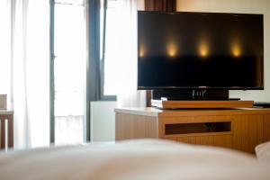 a flat screen tv sitting on a dresser in a bedroom at Hotel Krone in Steinenbronn +30 photos