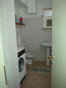 a bathroom with a toilet and a washing machine at La Terrazza nel carrùggio in Fezzano