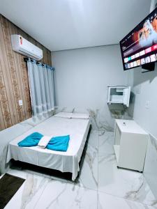 a hotel room with a bed and a tv at Hotel Entre Rios in Paraíso do Tocantins