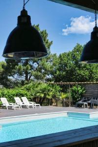 uma piscina com duas cadeiras e duas luzes em CASA di u cuginu em Calenzana