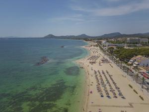 an aerial view of a beach with chairs and umbrellas at Apartamento Anamsa in Port de Pollensa