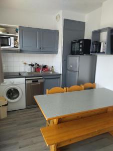 uma cozinha com uma mesa e um fogão forno superior em Appart terrasse Superdevoluy em Le Dévoluy