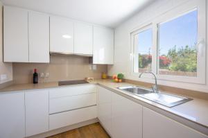 a white kitchen with a sink and a window at Casara Tres - 2 Dormitorios - Jardín y acceso Privado a la Playa in Zahora +36 photos