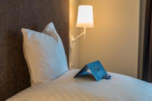 a book sitting on top of a bed with a pillow at Hotel Krone in Steinenbronn