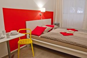 a bedroom with a bed and a table and a yellow chair at Budget Apartment in Prague