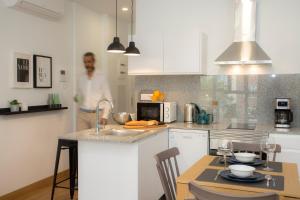 Un homme est debout dans une cuisine avec une table dans l'établissement Ruzafa Lander by SingularStays, à Valence