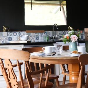 a kitchen with a table and chairs and a sink at Brackenhill Glamping - Safari Tent with Hot Tub - Sleeps 6 in Ivybridge