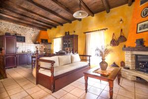 a living room with a couch and a fireplace at Samonas - Orange villa Diktamos in Khiliomoudhoú