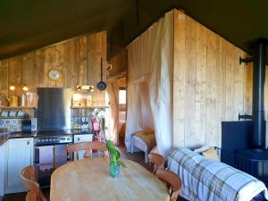 アイビーブリッジにあるBrackenhill Glamping - Safari Tent with Hot Tub - Sleeps 6のテーブル付きの部屋、ソファ付きのキッチンが備わる客室です。