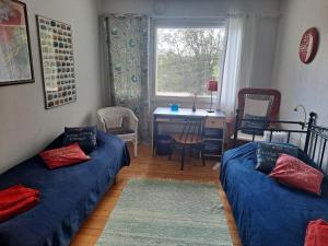 een kamer met 2 bedden, een bureau en een raam bij Villa Amy in Mikkeli