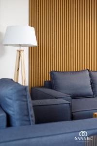a living room with two blue couches and a lamp at Apartament Premium Marin - Pinea Apartments Pobierowo in Pobierowo