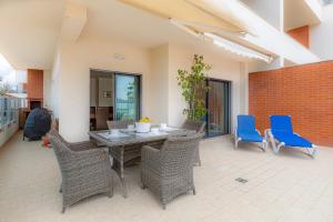 un patio avec une table et des chaises en bois dans l'établissement Dunas Triplex, à Lagos