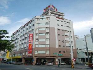 a large building on a city street with cars parked at Hua Tong Hotel in Hualien City