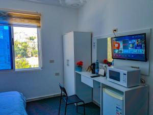 a room with a desk with a computer and a tv at Full panorama Jerash (PLUS) in Jerash