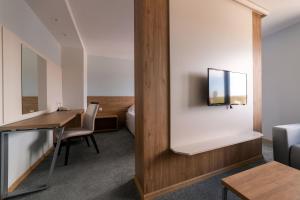 a room with a desk and a tv on a wall at Hotel Verticalplus in Haskovo