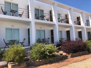 a white building with chairs on the balconies at Alto da Lua in Aljezur