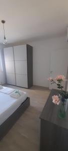 a room with a bed and a table with a vase with flowers at Casa Elide in Cavallino di Lecce