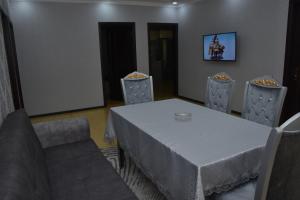 a dining room with a white table and chairs at Villa_Nihad in Gabala