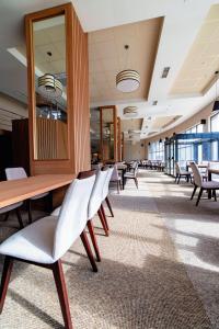 a waiting room with chairs and a table and mirrors at Hotel Verticalplus in Haskovo