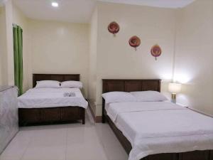 a bedroom with two beds and a couch at blue starfish villa in Panglao